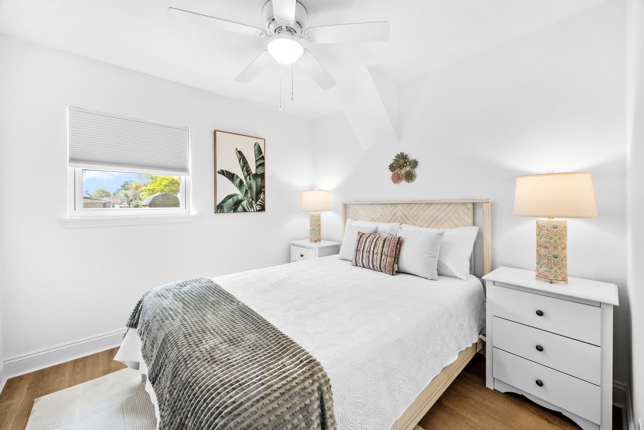 White primary bedroom with woven headboard