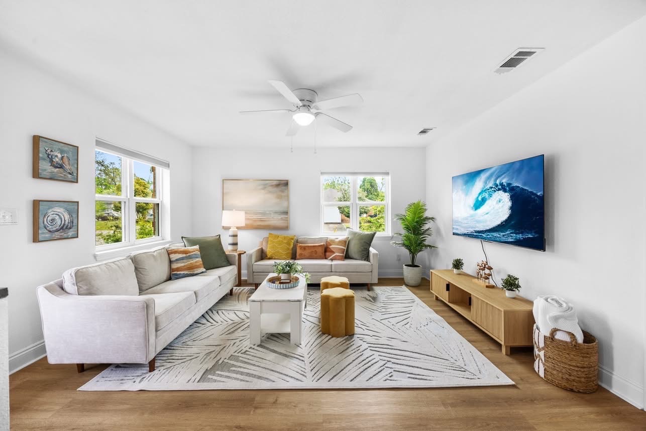 Bright living room with two sofas and palm rug